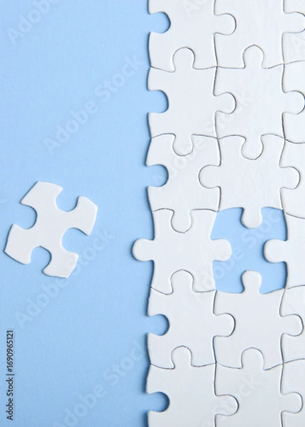 Fototapeta White puzzle on a colored background top view.. Vertical photo format