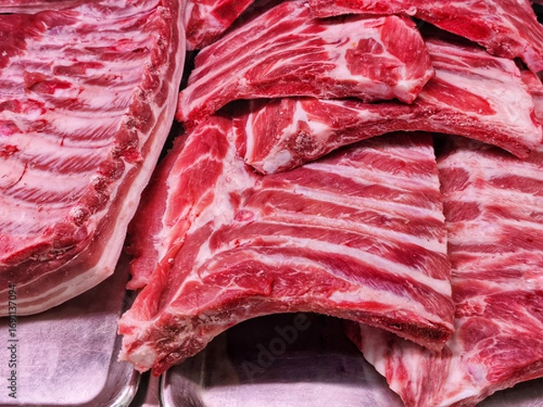 Fototapeta Raw pork ribs in tray on counter at store. Fresh fresh not frozen meat displayed in supermarket. Close-up.