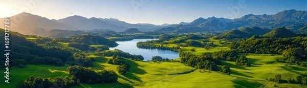 Obraz Stunning panoramic view of lush green hills, a winding river, and distant mountains under a partly cloudy sky.