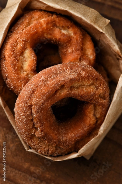 Obraz A brown paper bag filled with fresh baked Apple Cider Donuts.