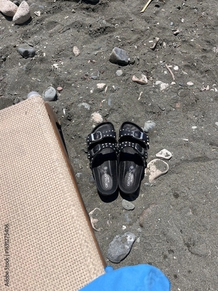 Obraz slippers on a black beach