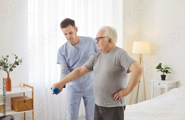 Fototapeta Elderly man performs dumbbell exercises with the support of a doctor or caregiver, emphasizing the role of healthcare in rehabilitation and physiotherapy. A structured recovery session unfolds.