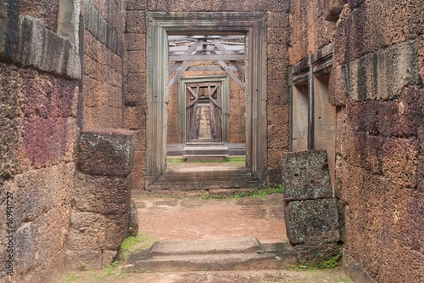 Obraz Corridor of Stone Walls and pillars to a Wood Door in Siem Reap Angkor Wat Temple Cambodia Asia