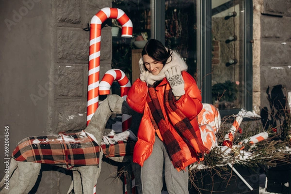 Obraz A woman walks along a city street on Christmas Eve in search of gifts and a good mood