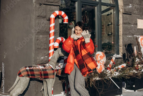 Obraz A woman walks along a city street on Christmas Eve in search of gifts and a good mood