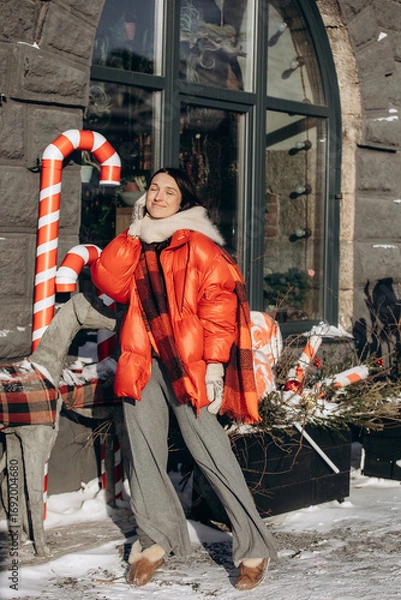 Obraz A woman walks along a city street on Christmas Eve in search of gifts and a good mood