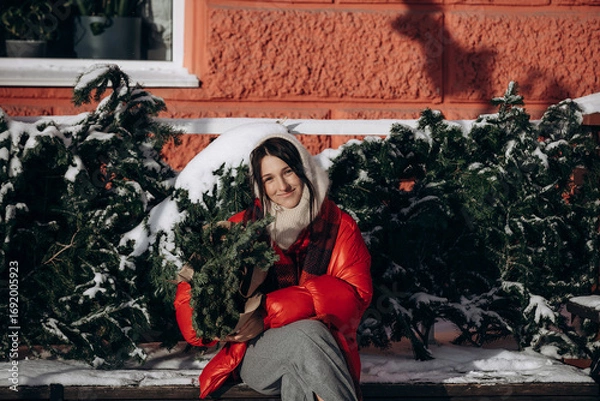Obraz A woman walks along a city street on Christmas Eve in search of gifts and a good mood