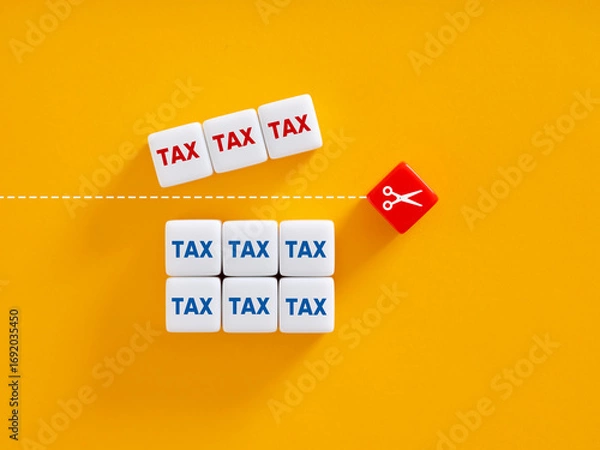 Fototapeta Scissors separating high taxes from low taxes on yellow background