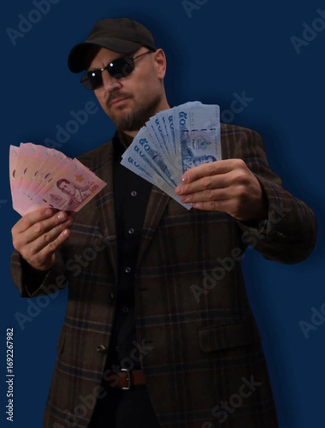 Fototapeta Counting quality banknotes held by a person in outdoor setting during daylight hours in a busy market area