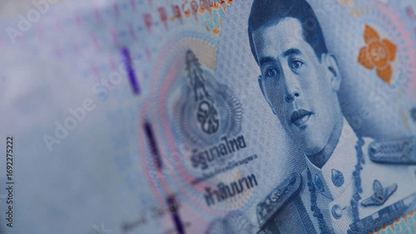 Fototapeta Counting Thai banknotes at a table during a financial transaction in Thailand