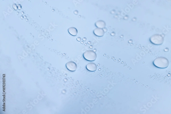 Fototapeta a smooth surface of light blue color covered with water , close up, a beautiful wet blue film in a large number of water drops