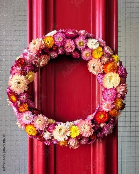 Obraz Flower wreath on red door background