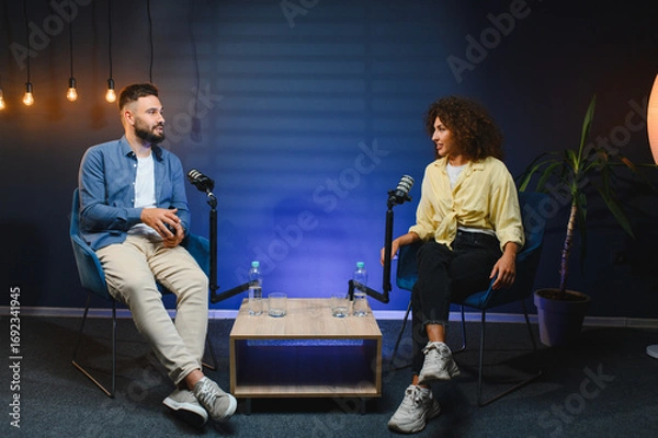 Fototapeta Two content creators recording podcast in professional studio