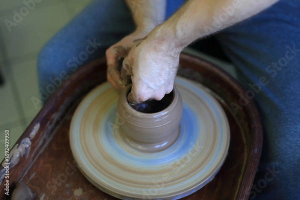 Fototapeta Crafting Clay: Hands at the Pottery Wheel