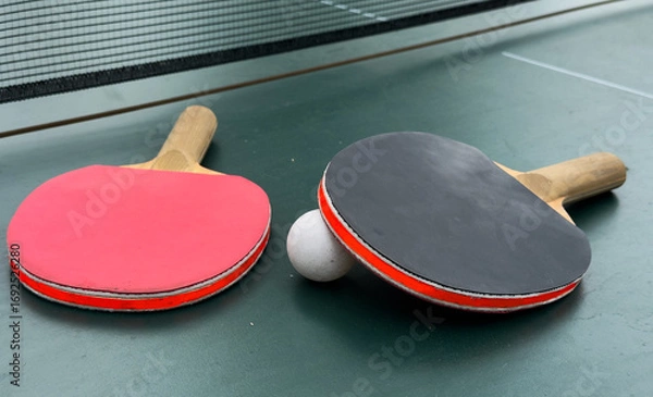 Fototapeta Two ping pong rackets and ball on table
