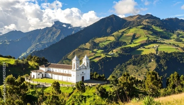 Fototapeta Panoramic view of a white church nestled in a valley amidst lush green hills and mountains