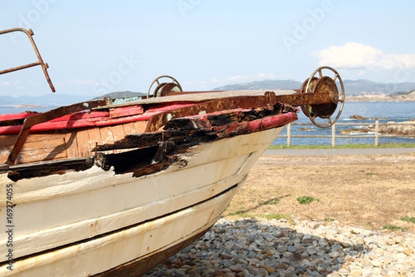 Fototapeta old and rusty fishing ship in a view point