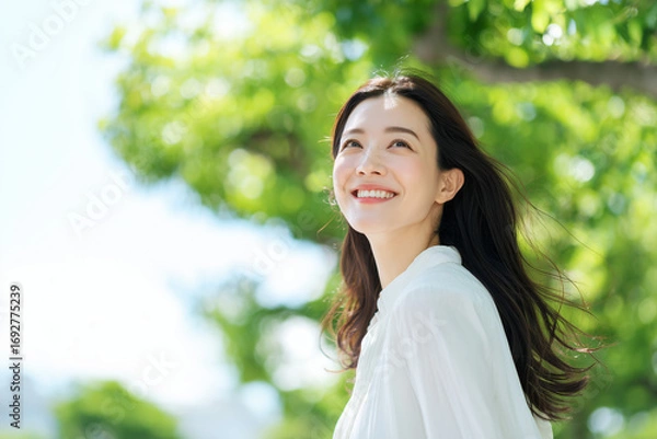 Obraz 緑豊かな木の下で微笑む美しい日本人女性