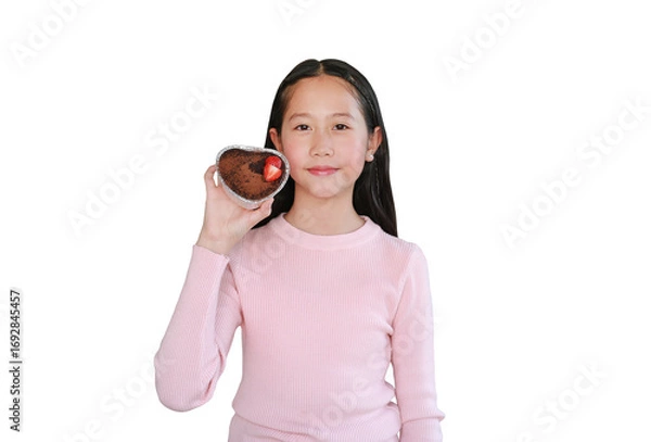 Fototapeta Portrait of pretty Asian girl showing chocolate cake topped with strawberry isolated on white background. Image with clipping path.