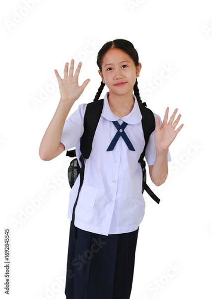 Fototapeta Portrait of Asian student girl in school uniform waving hand hello while carrying backpack bag isolated on white studio background.