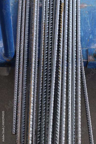 Fototapeta Reinforcement at the metal warehouse, selective focus. Construction iron rods with rust spots. Close-up of steel reinforcement. Warehouse of building materials. Repair and construction concept