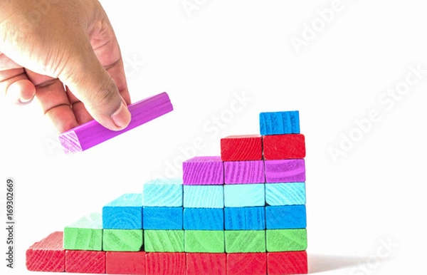 Obraz Make success,Concept of building success foundation. Hand put red puzzle wooden blocks in the shape of a staircase
