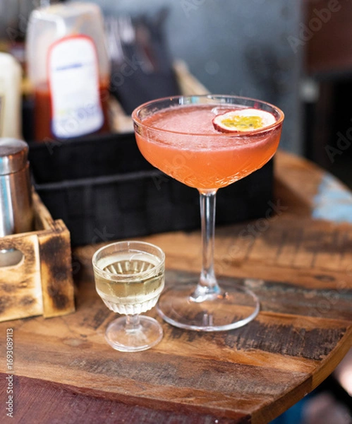 Obraz Pornstar Martini cocktail on a bar counter with beautiful bokeh in the background