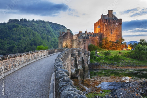 Fototapeta Eilean Donan Castle, Scotland, reflecting itself into the water during evening.