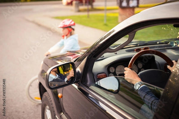 Obraz Accident. Girl on the bicycle crosses the road in front of a car