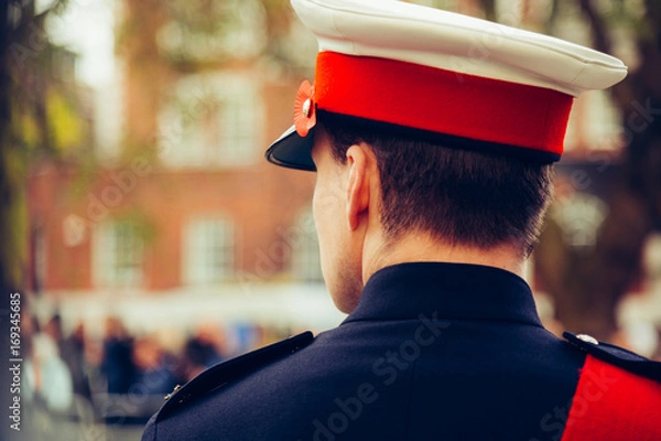 Fototapeta A telephoto shot of a soldier looking at blurred crowds during Remembrance Day
