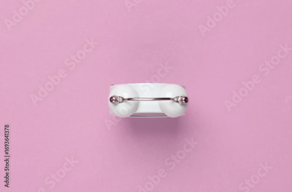 Fototapeta Top view of alarm clock bell on pink background