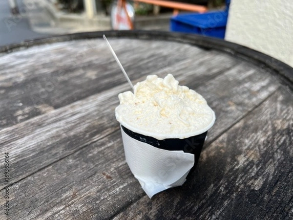 Obraz 木目のテーブルの上に置かれたカップに入ったアイス