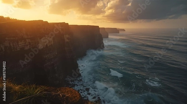 Fototapeta A stunning coastal landscape featuring majestic cliffs and the vast ocean during a spectacular golden sunset