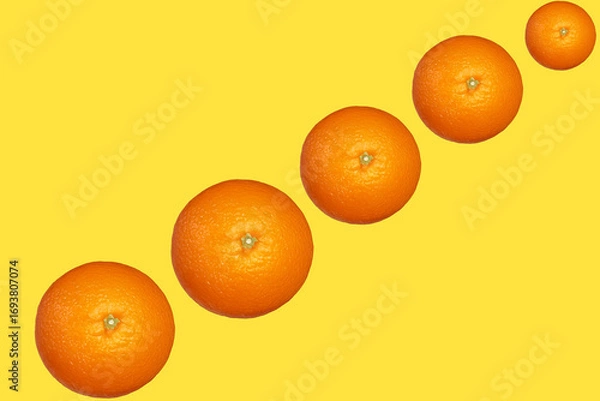 Fototapeta 黄色い背景に斜めに並んだみかん