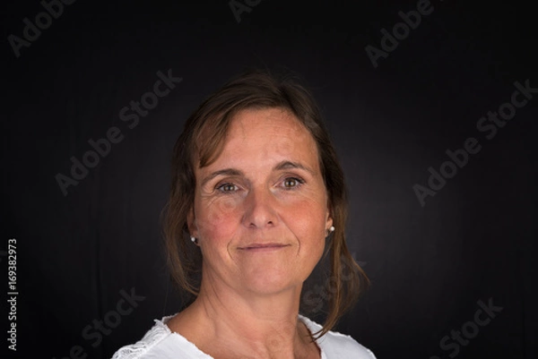 Obraz portrait of candid attractive mid-aged caucasian female adult - studio shot in front of dark background