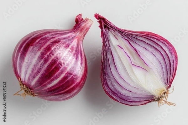 Fototapeta Two red onions, one whole and one halved, on a light background