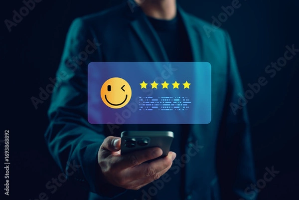 Fototapeta Customer showing five-star feedback on mobile phone with smiley face emoji, representing high satisfaction, positive user experience and quality service review.