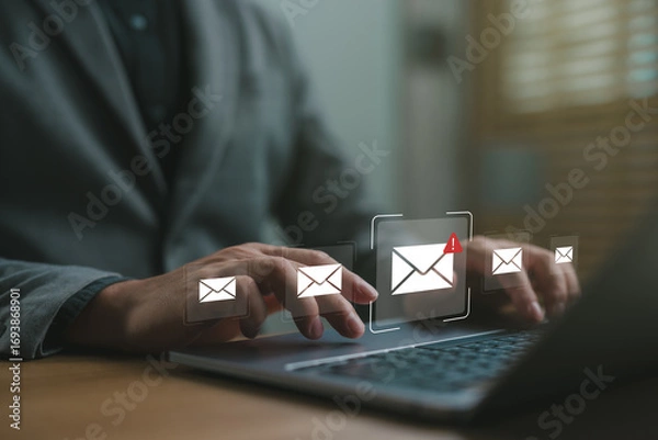 Fototapeta Businessman checking email notifications on laptop with alert icon, representing digital communication, work messages, productivity and online correspondence in the workplace.