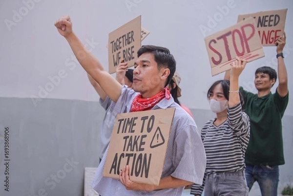 Fototapeta Young Asian Man With Red Bandana Raising Fist While Calling For Immediate Action And Change