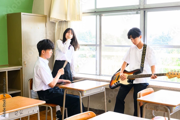 Fototapeta 文化祭に向けてバンド練習をする生徒たち　学校の教室での青春イメージ
