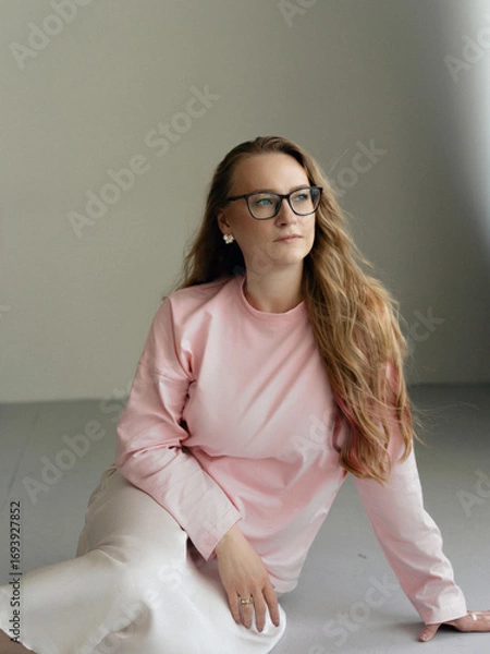 Fototapeta Young blondie attractive woman in eye glasses siting in studio. Business smart woman concept