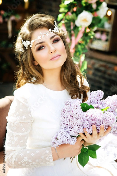 Fototapeta Stylish bride with a bright make-up and a gentle hairstyle. Summer girl with bouquet of flowers in hands