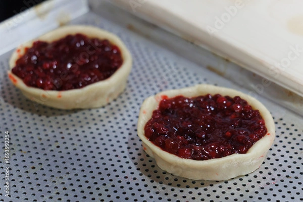 Fototapeta Delicious and Homemade Mini Pies Filled with Cherry Filling Resting on a Baking Tray