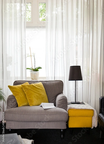 Obraz Cosy fabric armchair or love seat with yellow pillows in bright lightened living room