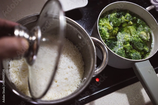Obraz Rice and broccoli in pots on the stove