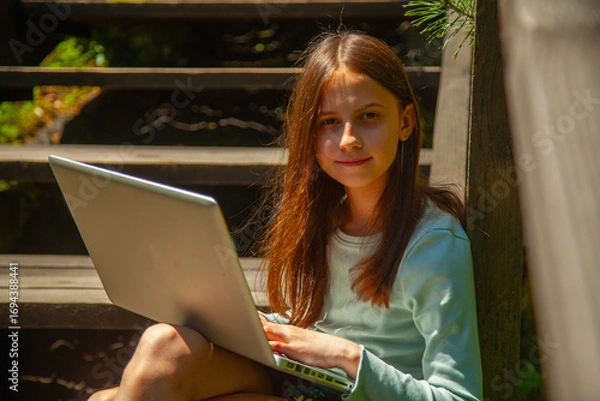 Obraz A barefoot girl enjoys quiet study time in nature.