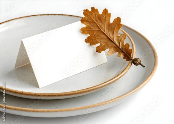 Fototapeta Elegant place setting featuring an oak leaf and card on stacked plates for decoration