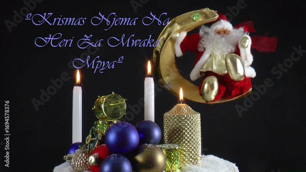 Fototapeta Warm Wishes for Christmas Joy 
A festive card with candles, baubles, and Santa Claus in the language 
