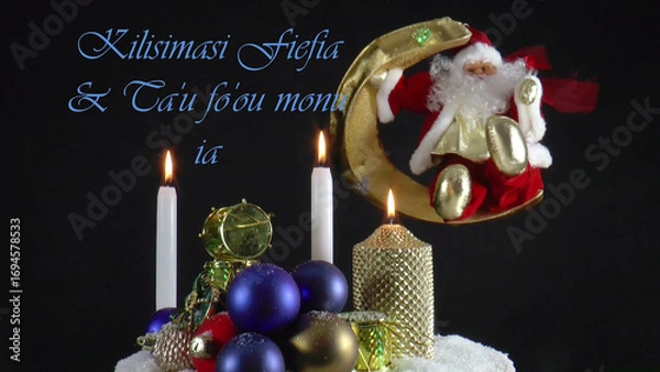Fototapeta Warm Wishes for Christmas Joy 
A festive card with candles, baubles, and Santa Claus in the language 
