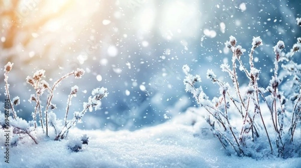 Fototapeta Snowflakes falling on a snowy landscape with a blurred background.